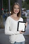 Young Woman With A Tablet On The Street Stock Photo