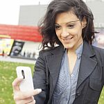 Young Woman With Cell Phone Walking Stock Photo