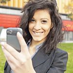 Young Woman With Cell Phone Walking Stock Photo