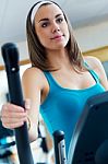 Young Woman With Elliptic Machine In The Gym Stock Photo