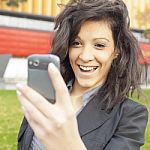 Young Woman With Funny Hair Smile Using Cell Phone Walking Stock Photo