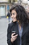 Young Woman With Smartphone Walking On Street Stock Photo