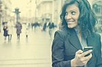 Young Woman With Smartphone Walking On Street Stock Photo